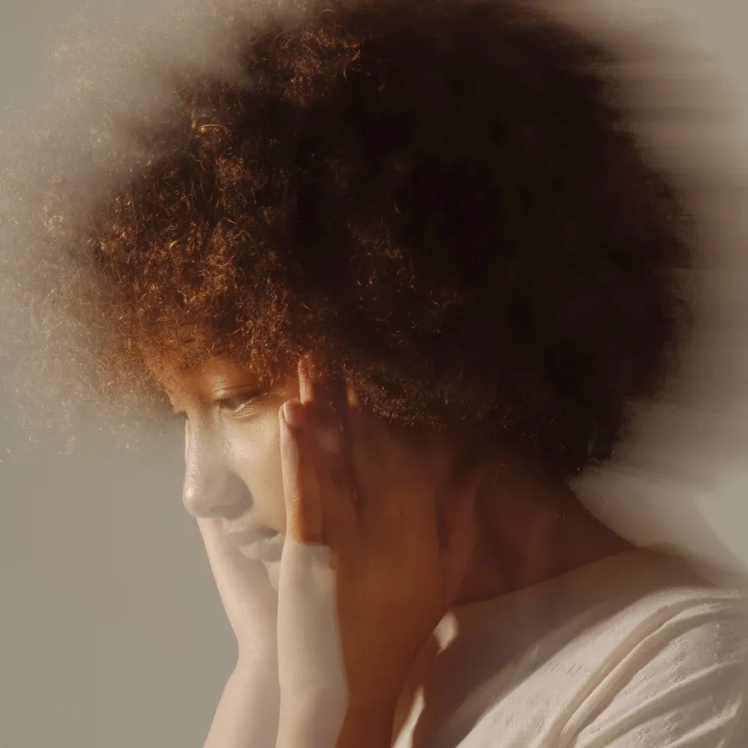 Une personne pensive, les mains posées sur le visage
