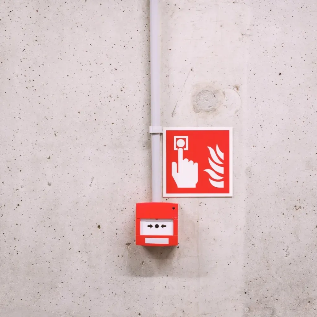 Un boîtier rouge d’alarme incendie sur un mur en béton